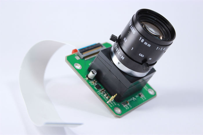 Kameramodul mit Linse auf grüner Platine und flexiblem Flachbandkabel, entwickelt für kundenspezifische Elektroniklösungen